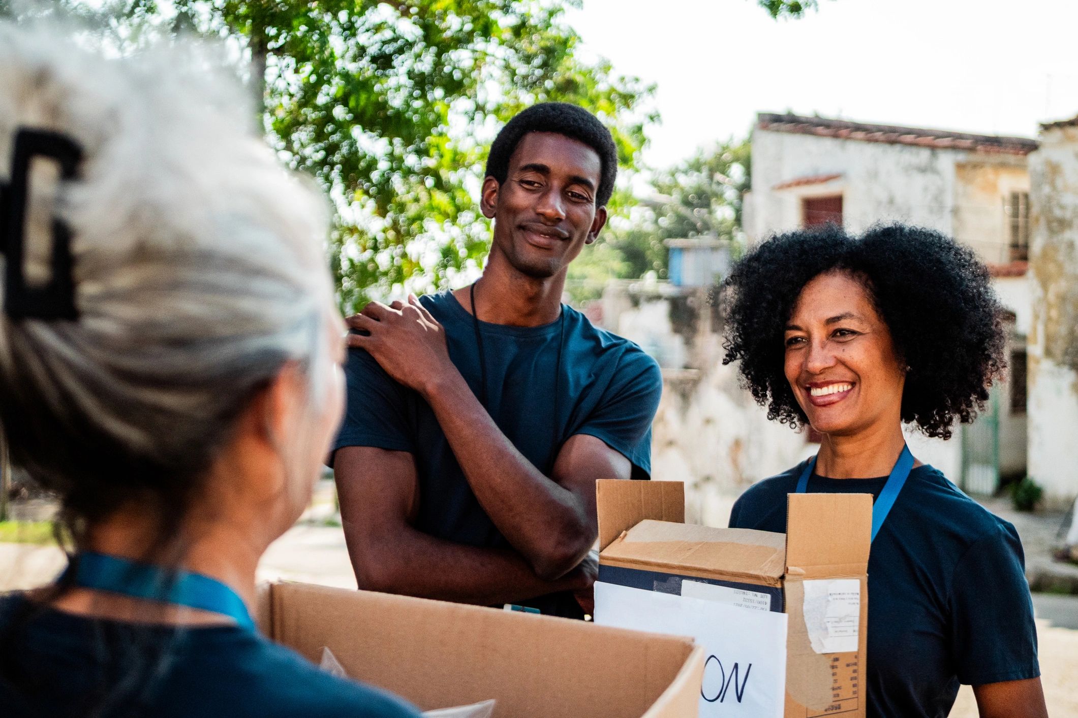 Volunteers talking while holding donation boxes outdoors
