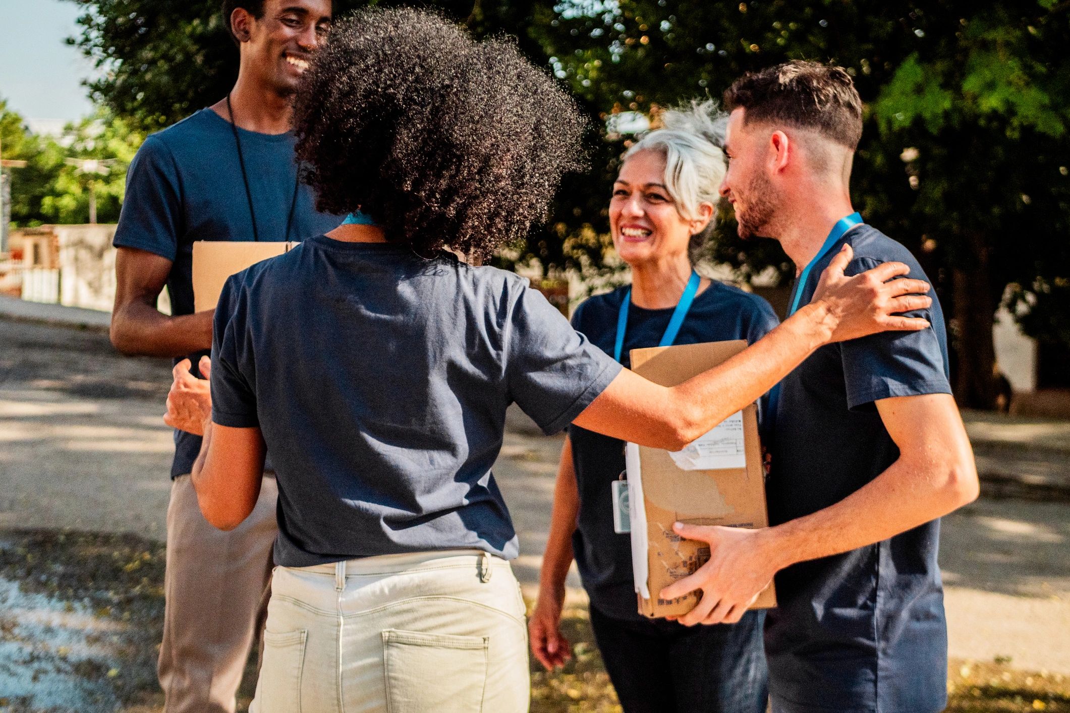 Community outreach volunteers holding donation boxes outdoors
